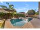 Private backyard pool with a mature hedge, palm trees, and umbrella, creating a serene and shaded oasis at 735 W Ivanhoe St, Gilbert, AZ 85233