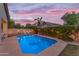 Inviting pool and backyard area with colorful sunset, lounge chairs, and landscaped privacy hedge with market lighting at 735 W Ivanhoe St, Gilbert, AZ 85233