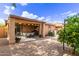 Backyard with desert landscaping, covered patio, string lights and small trees offering shade at 749 E Desert Moon Trl, San Tan Valley, AZ 85143