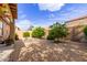 Low maintenance backyard featuring desert landscaping, mature trees, and lounge chairs at 749 E Desert Moon Trl, San Tan Valley, AZ 85143