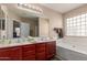 Bathroom featuring a double vanity, large mirror, and soaking tub for relaxation at 749 E Desert Moon Trl, San Tan Valley, AZ 85143
