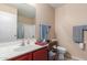 Bright bathroom featuring a vanity with sink, shower, and toilet with decoratively organized shelving at 749 E Desert Moon Trl, San Tan Valley, AZ 85143