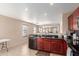 Functional kitchen featuring granite countertops, dark wood cabinetry, black appliances, and an open layout to the living area at 749 E Desert Moon Trl, San Tan Valley, AZ 85143