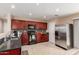 Well-maintained kitchen featuring dark wood cabinetry, granite countertops, stainless steel appliances, and tile flooring at 749 E Desert Moon Trl, San Tan Valley, AZ 85143