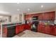 Well-equipped kitchen featuring ample cabinet space, sleek black appliances, and neutral tile flooring for easy maintenance at 749 E Desert Moon Trl, San Tan Valley, AZ 85143