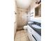 Bathroom with a granite countertop, tiled shower, and decorative mirror at 7513 E Roosevelt St, Scottsdale, AZ 85257