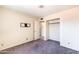 Bedroom featuring neutral carpet, white trim and an open closet at 7513 E Roosevelt St, Scottsdale, AZ 85257