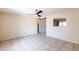 Cozy bedroom with ceiling fan, neutral walls, tile flooring, and view to kitchen at 7513 E Roosevelt St, Scottsdale, AZ 85257