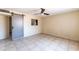 The bright bedroom features tile flooring, a ceiling fan and pass-through to kitchen at 7513 E Roosevelt St, Scottsdale, AZ 85257