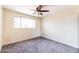 Bright bedroom with a ceiling fan, window, and neutral-toned carpet at 7513 E Roosevelt St, Scottsdale, AZ 85257