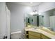 Bathroom featuring marble countertops, mirrored walls, cabinet storage and toilet at 7811 N 46Th Ave, Glendale, AZ 85301