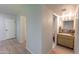 Hallway with wood-look floors leading to bathroom with marble countertops at 7811 N 46Th Ave, Glendale, AZ 85301