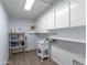 Bright laundry room with sleek white cabinets, shelving, and utility sink at 7811 N 46Th Ave, Glendale, AZ 85301