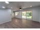 Bright living room with wood-look floors and large window and sliding glass doors at 7811 N 46Th Ave, Glendale, AZ 85301