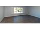 Bright room featuring wood-look floors, a large window with charming shutters, and neutral walls at 7811 N 46Th Ave, Glendale, AZ 85301