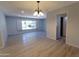 Open living room with wood-look floors, a large window, and seamless access to the kitchen at 7811 N 46Th Ave, Glendale, AZ 85301