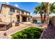 Large backyard with a pool, artificial grass, BBQ area, and covered patio, perfect for entertainment at 8341 W Palo Verde Ave, Peoria, AZ 85345