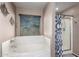 Well-lit bathroom featuring a garden tub and a separate shower with glass door at 8341 W Palo Verde Ave, Peoria, AZ 85345