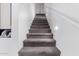 Carpeted staircase with white walls, modern lighting, and decorative wall art at 8341 W Palo Verde Ave, Peoria, AZ 85345