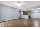 Open-concept living area with wood-look flooring, ceiling fan, and an adjacent kitchen at 10136 E Southern Ave # 1074, Mesa, AZ 85209