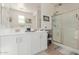 Bathroom featuring double vanity sinks, white cabinets, and a glass-enclosed shower at 10138 W Wood St, Tolleson, AZ 85353
