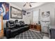 Cozy bedroom featuring a reclining loveseat, ceiling fan and sports themed decor at 10138 W Wood St, Tolleson, AZ 85353