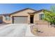 Charming single-story home with a stone facade, landscaped front yard, and two-car garage at 10138 W Wood St, Tolleson, AZ 85353