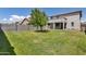 Large grassy backyard features privacy wall and young shade tree, perfect for entertaining at 10221 W Puget Ave, Peoria, AZ 85345