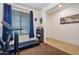 Bright bedroom with neutral walls and tiled floor, featuring a treadmill, shelving unit and natural light from the window at 10221 W Puget Ave, Peoria, AZ 85345