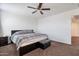 Bedroom with gray plaid comforter, ceiling fan, and plush brown carpet at 10221 W Puget Ave, Peoria, AZ 85345