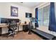 Bedroom featuring a sleek treadmill next to a work-from-home setup with multiple monitors and a comfortable desk at 10221 W Puget Ave, Peoria, AZ 85345