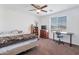 Bright bedroom featuring a ceiling fan, and large window overlooking the front yard at 10221 W Puget Ave, Peoria, AZ 85345