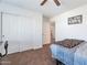Bedroom with white closet doors, neutral carpet, and bed with striped comforter at 10221 W Puget Ave, Peoria, AZ 85345