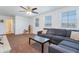 Upstairs bonus room with gray sectional sofa, ceiling fan, and adjacent bathroom at 10221 W Puget Ave, Peoria, AZ 85345
