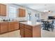 Bright kitchen with wood cabinets, island, and dining area with sliding doors to the backyard at 10221 W Puget Ave, Peoria, AZ 85345