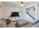 Cozy living room with gray sectional sofa, ceiling fan, and a TV on a white media console at 10221 W Puget Ave, Peoria, AZ 85345