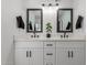 Bathroom with a dual sink vanity, white marble countertop, and dark framed mirrors at 1038 N 78Th Pl, Scottsdale, AZ 85257