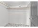 A well-organized closet space with patterned floors and a sturdy wooden rod for hanging clothes at 1038 N 78Th Pl, Scottsdale, AZ 85257