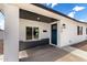 Inviting covered front entrance with dark blue door and stylish exterior lighting fixture at 1038 N 78Th Pl, Scottsdale, AZ 85257