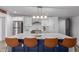 Close up of an island with marble countertop, seating, and modern light fixture at 1038 N 78Th Pl, Scottsdale, AZ 85257