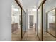 Hallway with wood floors and mirrored closet doors leads to a bathroom with double sinks at 10836 N 108Th N Pl, Scottsdale, AZ 85259