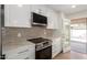 A close-up of the kitchen with stainless steel appliances, white cabinets, and a view of the pool at 10836 N 108Th N Pl, Scottsdale, AZ 85259