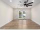 Well-lit living room showcasing wood floors, ceiling fan, and glass doors to the pool at 10836 N 108Th N Pl, Scottsdale, AZ 85259