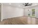 Bright living room with wood floors, ceiling fan, and glass doors to backyard at 10836 N 108Th N Pl, Scottsdale, AZ 85259