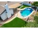 Inviting backyard with a sparkling pool, manicured artificial turf, and covered patio creates an ideal space for outdoor living at 10836 N 108Th N Pl, Scottsdale, AZ 85259