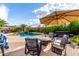 Relaxing backyard with a pool, comfortable seating under an umbrella, and a hot tub, creating a perfect oasis at 12526 S 176Th Ave, Goodyear, AZ 85338
