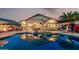 Beautiful backyard featuring a sparkling pool reflecting the house, covered patio and poolside lounge chairs at 12526 S 176Th Ave, Goodyear, AZ 85338
