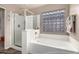 Bathroom featuring a walk-in shower, a tub, and a window made of glass blocks at 12526 S 176Th Ave, Goodyear, AZ 85338