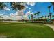 Lush green park and lakefront area with palm trees, water slide, and recreational space for community enjoyment at 12526 S 176Th Ave, Goodyear, AZ 85338