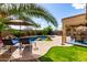 A private backyard oasis with a pool, waterfall feature, patio, and lush landscaping at 12526 S 176Th Ave, Goodyear, AZ 85338